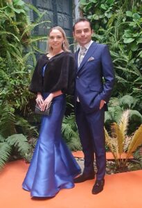 Pareja elegante, hombre con traje de gala azul oscuro.