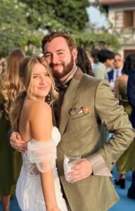 Novio con traje verde oliva de alta costura brindando.