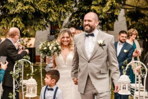 Novios caminando al aire libre, novio con traje gris claro elegante.