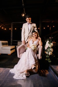 Novio sentado en interior elegante luciendo traje beige premium.