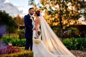 Boda de noche, novios bajo luces, él con traje azul oscuro.