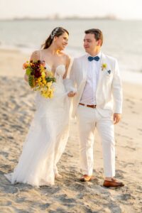 Novio vistiendo un traje de lino blanco a la medida por Carlos A. Ceballos en boda de playa