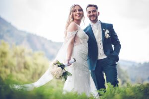 Pareja posando en el campo, novio viste traje verde sartorial