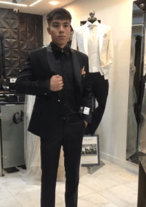 Caballero proyectando elegancia absoluta con un smoking negro estilo "total black" en el atelier.