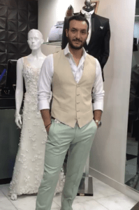 Novio luciendo un look casual y fresco con chaleco beige y pantalón claro en la boutique.
