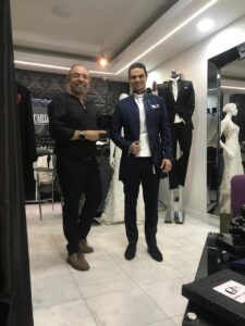Dos clientes posando con elegantes trajes negros.