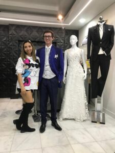 Pareja en el atelier, él luce un traje azul oscuro.