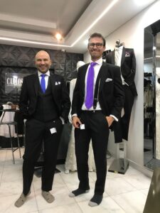 Clientes posando con trajes formales en azul y negro.