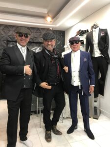 Tres caballeros luciendo trajes negros a la medida.