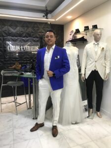 Caballero con un look audaz combinando chaqueta azul cobalto y pantalón blanco.