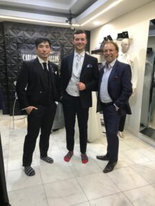 Pareja de caballeros modelando sus trajes de gala sartoriales en el taller.