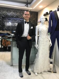 Caballero posando seguro con su traje negro a la medida.