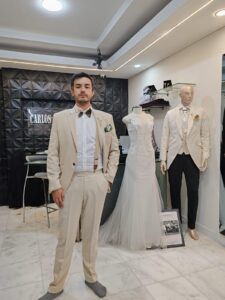 Caballero de pie con un fresco traje color arena.