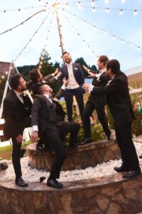 Grupo de amigos celebrando con trajes formales.