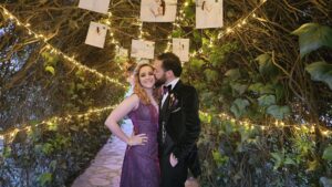 Romántico beso nocturno, el novio luce traje oscuro.