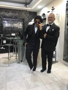 Pareja de hombres posando con elegantes trajes negros.