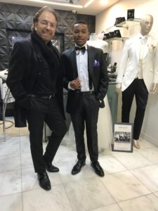 Dos clientes satisfechos con sus trajes a la medida.