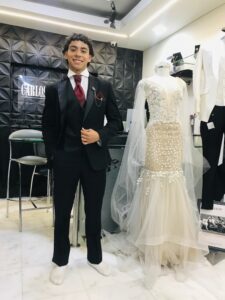 Caballero con traje oscuro y chaleco rojo brocado.