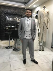 Novio modelando un traje gris claro completo.
