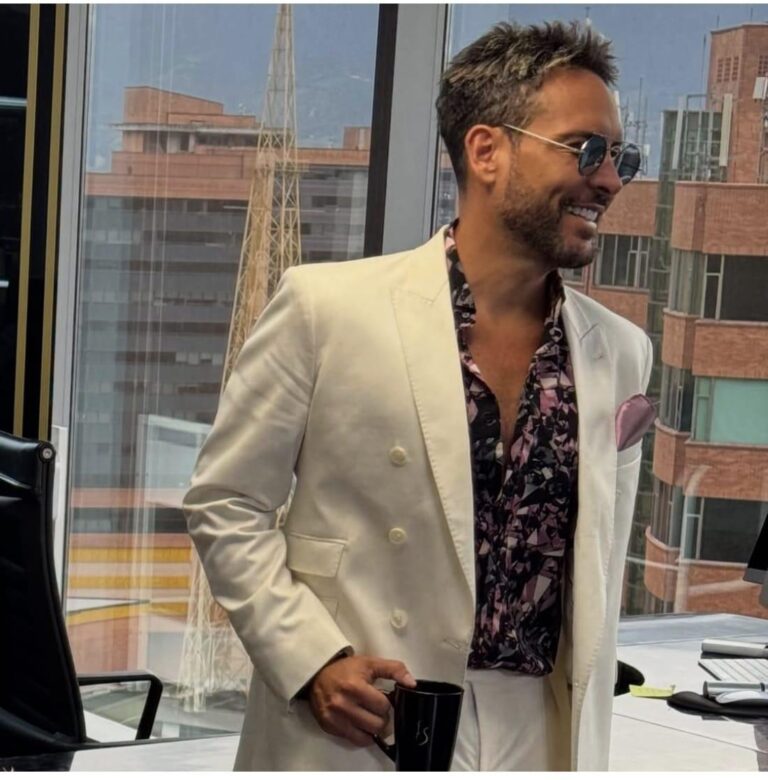 Hombre con traje beige sin corbata para evento casual.